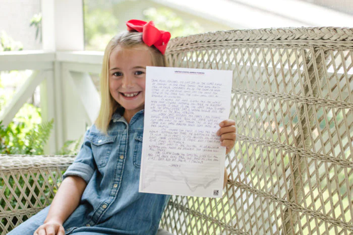 Girl holding Sandboxx Letter